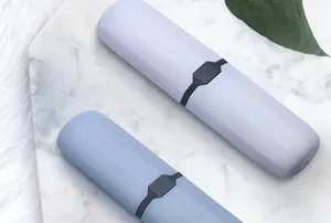 Vista de detalle de dos estuches portátiles para cepillos de dientes sobre mármol
