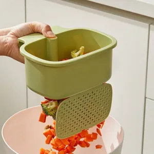 Green kitchen sink drain basket with press-to-open bottom lid for easy vegetable dumping