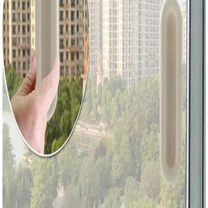 Close-up detail of the white adhesive handle installed on a sliding glass window.