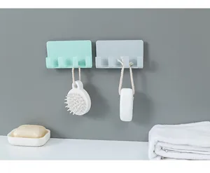 Adhesive wall mount with 4 hooks shown holding various bath accessories on grey wall