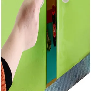 Close-up detail of a white adhesive door handle being installed on a green cabinet surface