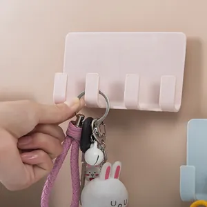 Pink adhesive wall-mounted phone charging holder with four hooks for keys and accessories.