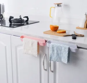 Kitchen cabinet door towel rack holding cleaning rags in a modern home kitchen setting