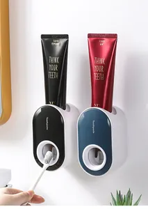 Detail view of two wall-mounted automatic toothpaste dispensers in black and navy blue.