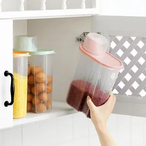 Large airtight plastic cereal storage containers with colorful lids in a kitchen cabinet.