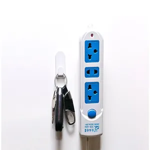 Detail of a white wall-mounted adhesive hook holding keys in a home setting.