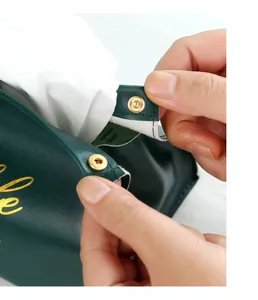 Close-up of gold snap buttons on a dark green leather tissue box holder