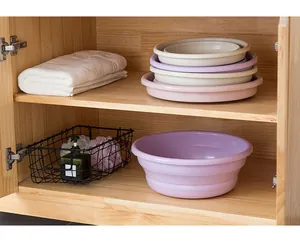 Foldable plastic wash basins stored efficiently in a wooden cabinet shelf