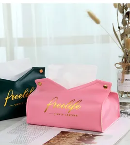Close-up of pink and dark green leather tissue boxes with elegant gold embossed lettering