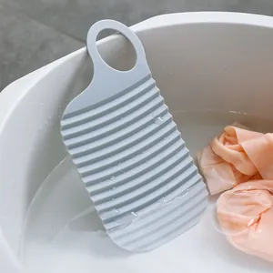 Draagbaar grijs siliconen mini wasbord voor delicate was getoond in een witte waterbak