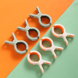 Große windfeste Bettdeckenclips auf orangefarbenem und grünem Hintergrund für Wäsche