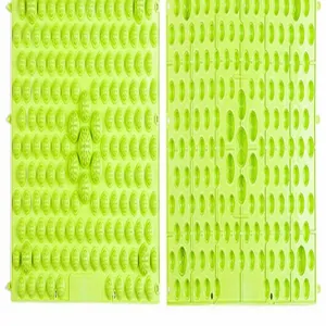 Detail view of green acupressure foot massage mat showing textured pressure points