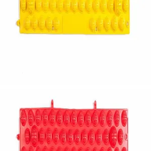 Close-up detail of textured acupressure foot massage mats in bright yellow and red colors