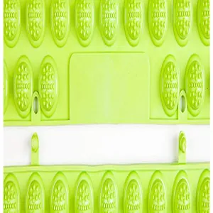Close-up detail of a green acupressure foot massage mat showing textured nodules