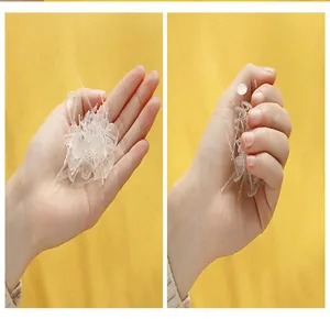 Close-up of transparent mushroom quilt fasteners held in hand showing compact design