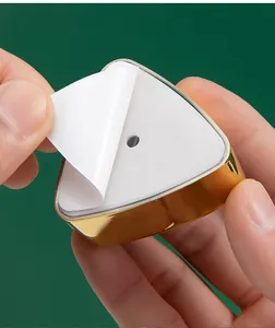 Detalle del dorso adhesivo fuerte de un toallero triangular dorado de lujo
