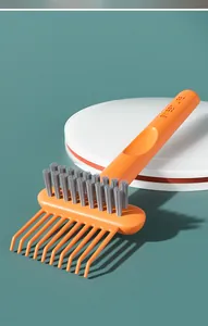 Detail showing the orange hairbrush cleaning claw with grey cleaning bristles on one side.