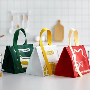 Drie kleurrijke geïsoleerde lunchtassen met schattige prints van fruit en toast op aanrecht