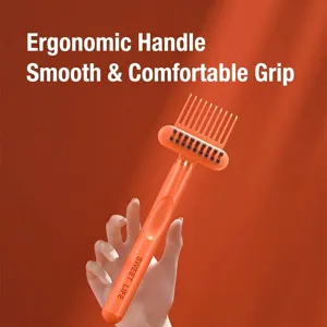 Ergonomic orange hairbrush cleaning tool with dual-sided bristles and comb claw design.