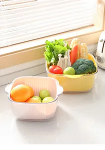 Paniers de drainage de cuisine double couche avec légumes et fruits frais sur un plan de travail