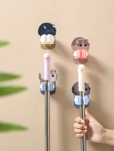 Detail view of cute cartoon cat mop and broom hooks mounted on a wall holding handles