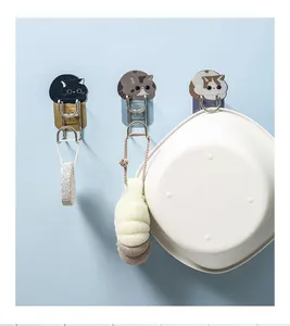 Wall-mounted cartoon cat hooks organizing a washbasin and bath accessories in a bathroom
