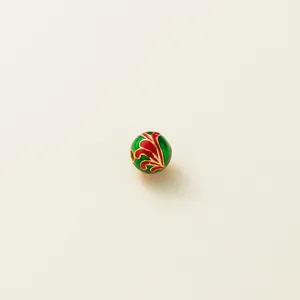 Close-up of 6mm green and red enamel spacer bead with gold-plated sterling silver detail