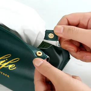 Luxury dark green leather tissue box with gold snap button detail and gold printing