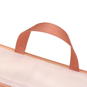 Close-up of durable webbed handle on pink oxford cloth compressible clothing storage bag