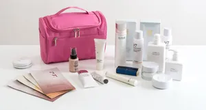 Pink waterproof Oxford travel toiletry bag shown with various cosmetics for size reference