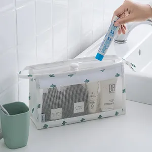 Detailed view of cactus print mesh toiletry bag being filled with bathroom items.