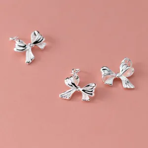Close-up of three polished 925 sterling silver bow pendants for DIY jewelry making
