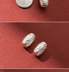 Macro detail of 999 fine silver barrel bead with retro engraved pattern for jewelry DIY