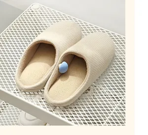 Close-up of blue mushroom quilt fixer clip attached to a soft beige striped slipper