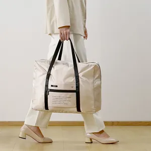 Large foldable beige polyester travel duffle bag with trolley sleeve and handle