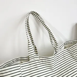 Primer plano de las correas de un bolso tote moderno de lona a rayas blancas y negras