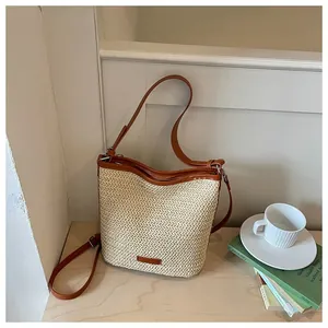 Detalle de un bolso bandolera minimalista de paja tejida para las vacaciones de verano