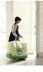 Large green striped cartoon frog quilt storage bag carried by a young girl