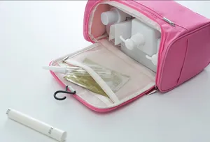 Macro detail of spacious open pink travel toiletry bag showing interior storage and hook