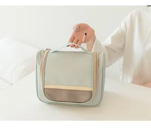 Close-up of a mint green waterproof hanging toiletry bag with brown leather accents.