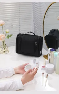 Professional large capacity black travel toiletry bag with three zippers on a vanity