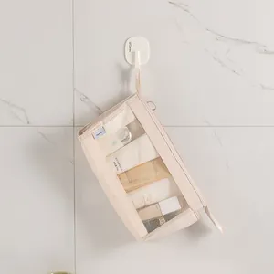 Minimalistische Reise-Kulturtasche aus Mesh, an einem Wandhaken im Bad aufgehängt