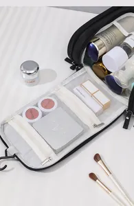 Close-up of open travel toiletry bag with compartments filled with cosmetics