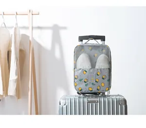 Waterproof travel shoe storage bag attached to silver suitcase trolley handle.