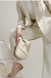 Close-up of a waterproof PU tech organizer bag held by a person in a beige suit