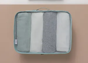 Vista dall'alto di un cubo da viaggio in rete blu con vestiti piegati ordinatamente