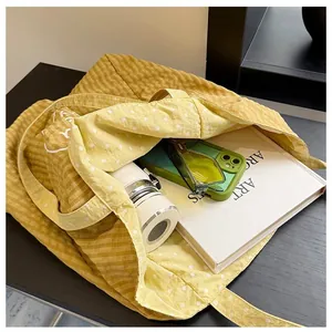 Detail view showing the large interior capacity of a yellow polka dot canvas tote bag