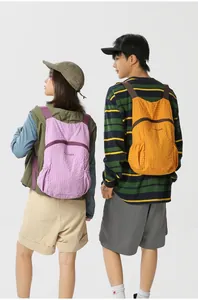 Detailed view of lightweight foldable backpacks in purple and orange for outdoor travel.