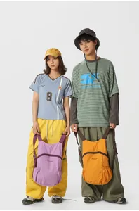Foldable lightweight outdoor backpacks for hiking and travel, shown on models in studio