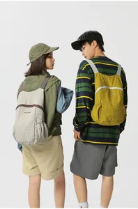 Detailed view of lightweight foldable outdoor backpacks worn by models from behind